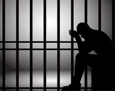 Silhouette of a Man Sitting in a Jail Cell